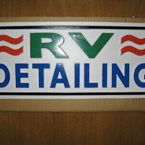 The framed logo of RV DETAILING on a wall