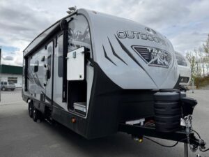 Gray travel trailer parked on asphalt lot.
