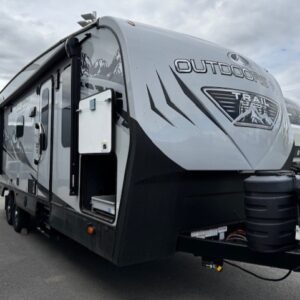 Gray travel trailer parked on asphalt lot.