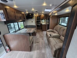 Modern RV interior with seating and kitchen.