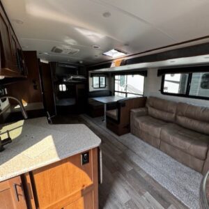 Modern RV interior with kitchen and sofa.