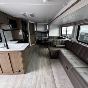 Modern RV interior with kitchen and seating.