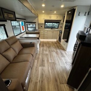 Modern RV interior with kitchen and seating.