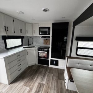 Modern RV kitchen interior with dining area.