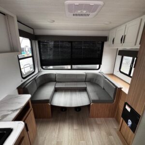 Modern RV interior with seating and table.