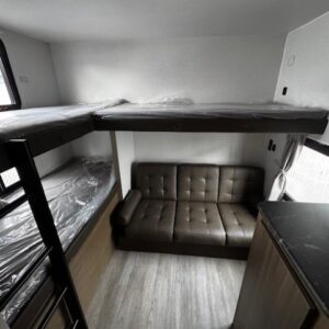 RV interior with bunk beds and sofa.