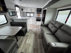 Modern RV interior with sofa and kitchenette.