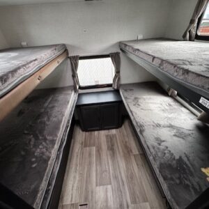 RV interior with four bunk beds.