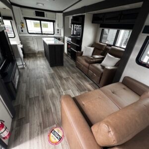Modern RV interior with kitchen and seating.