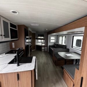 Modern RV interior with kitchen and seating.