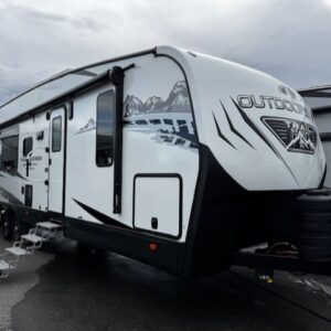 White travel trailer parked on a road.