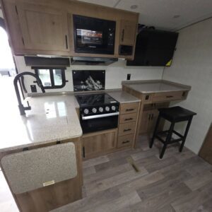 "Stylish camper kitchen with modern appliances and design."