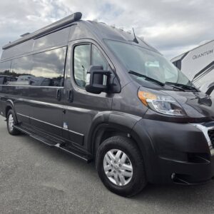 Sleek gray RV van parked in dealership lot.
