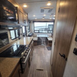 Modern camper kitchen with sleek appliances and dining.