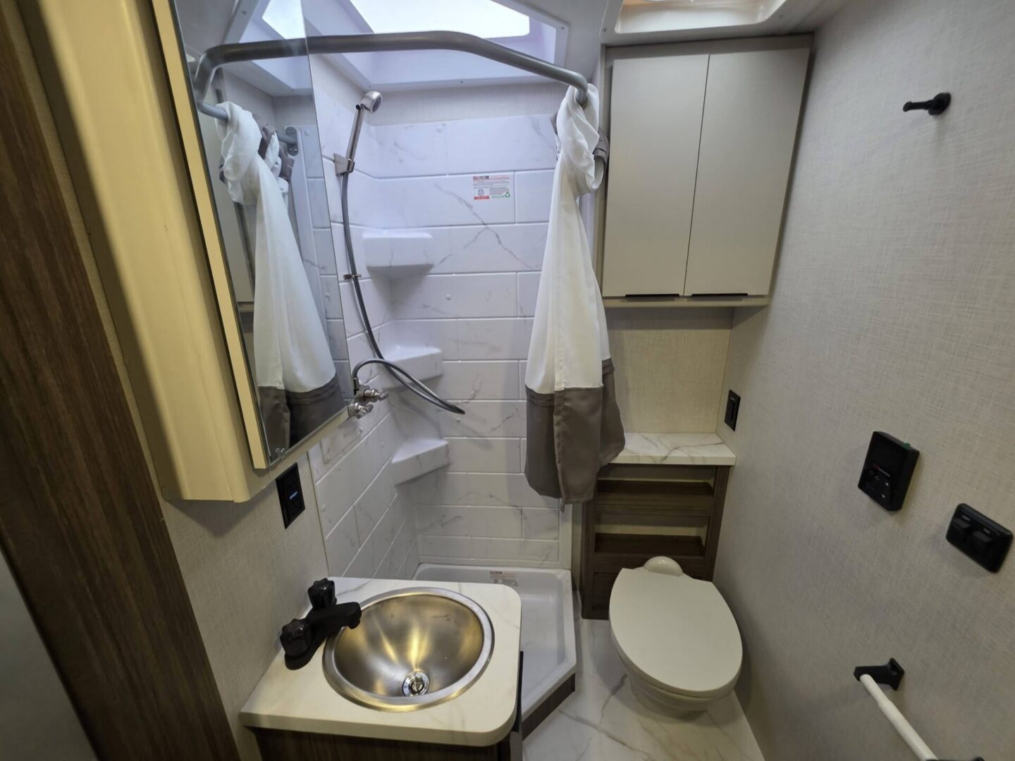 Compact bathroom with shower and modern fixtures.