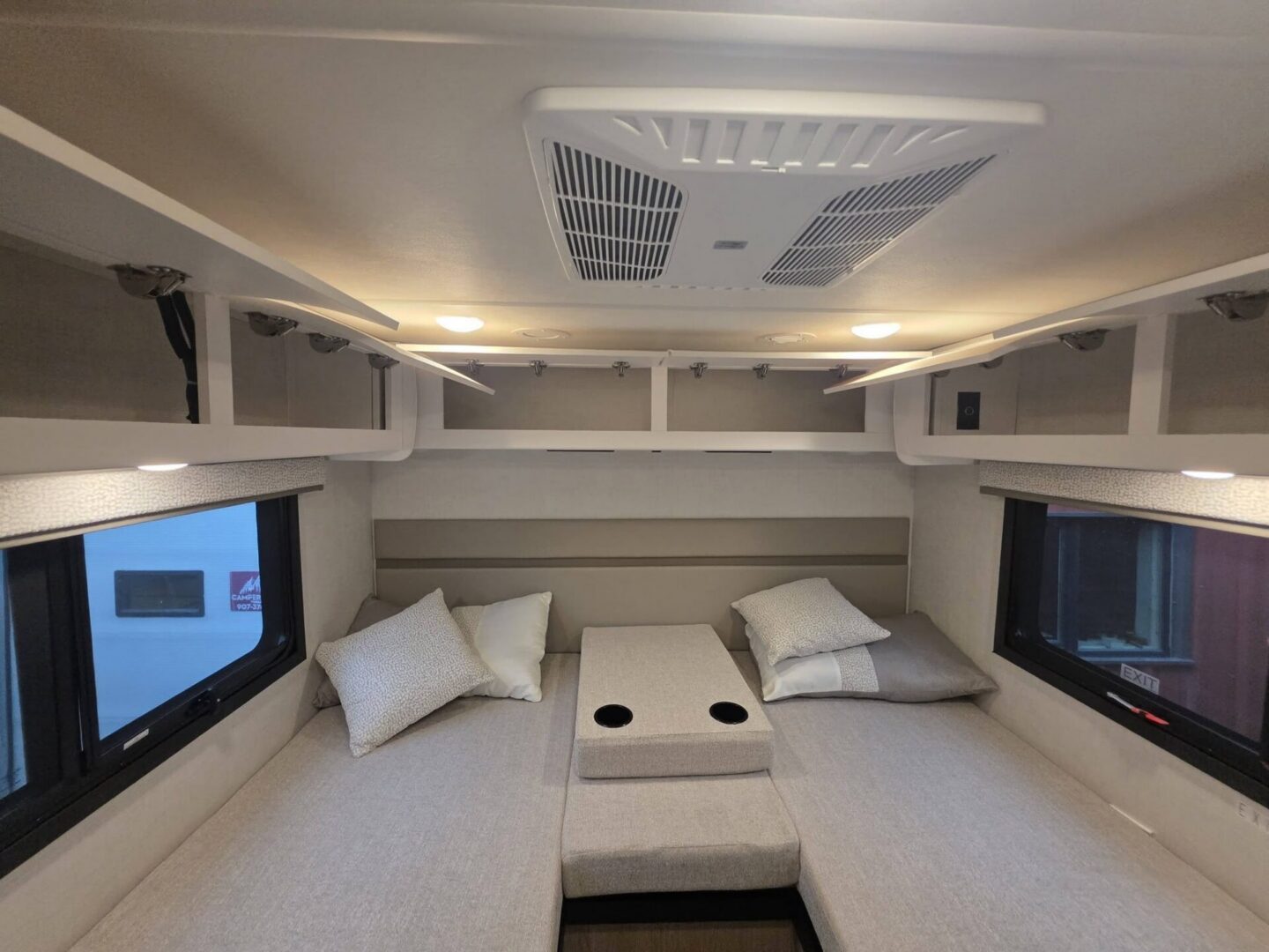 Cozy camper seating area with overhead storage.