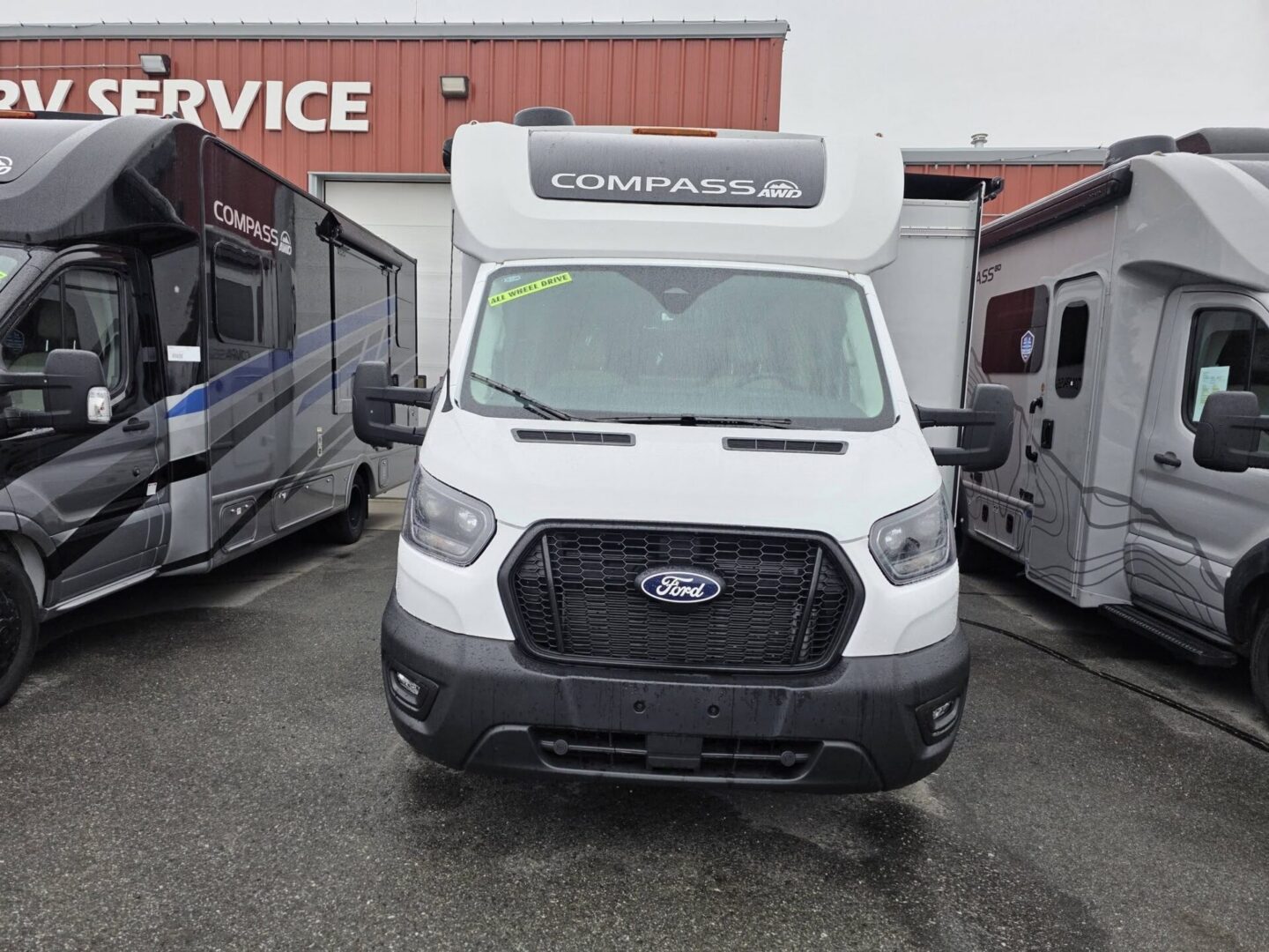 White Ford Compass RV parked at dealership.