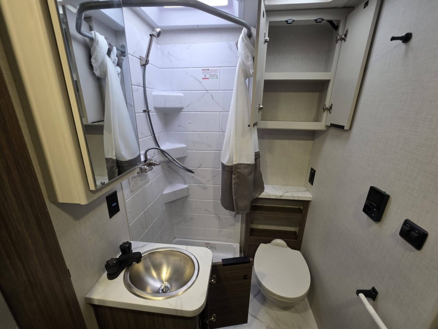 Compact bathroom with modern fixtures and storage.